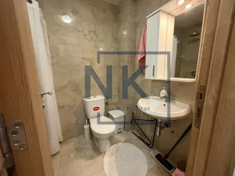 Compact bathroom with a washbasin, toilet, and a shower with a curtain. - image 9