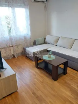 Dnevna soba sa ugaonom garniturom, stočićem i prozorom sa zavesama. - image 4