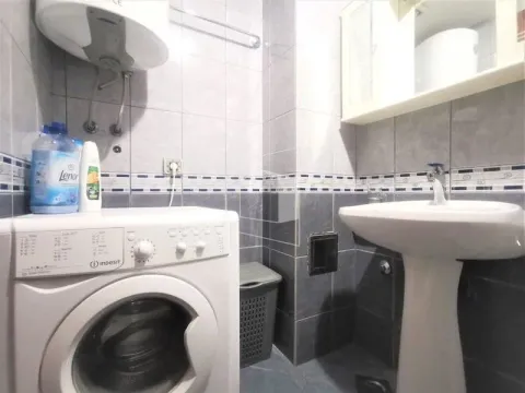 Smaller bathroom with a sink, washing machine, and water heater. - image 12