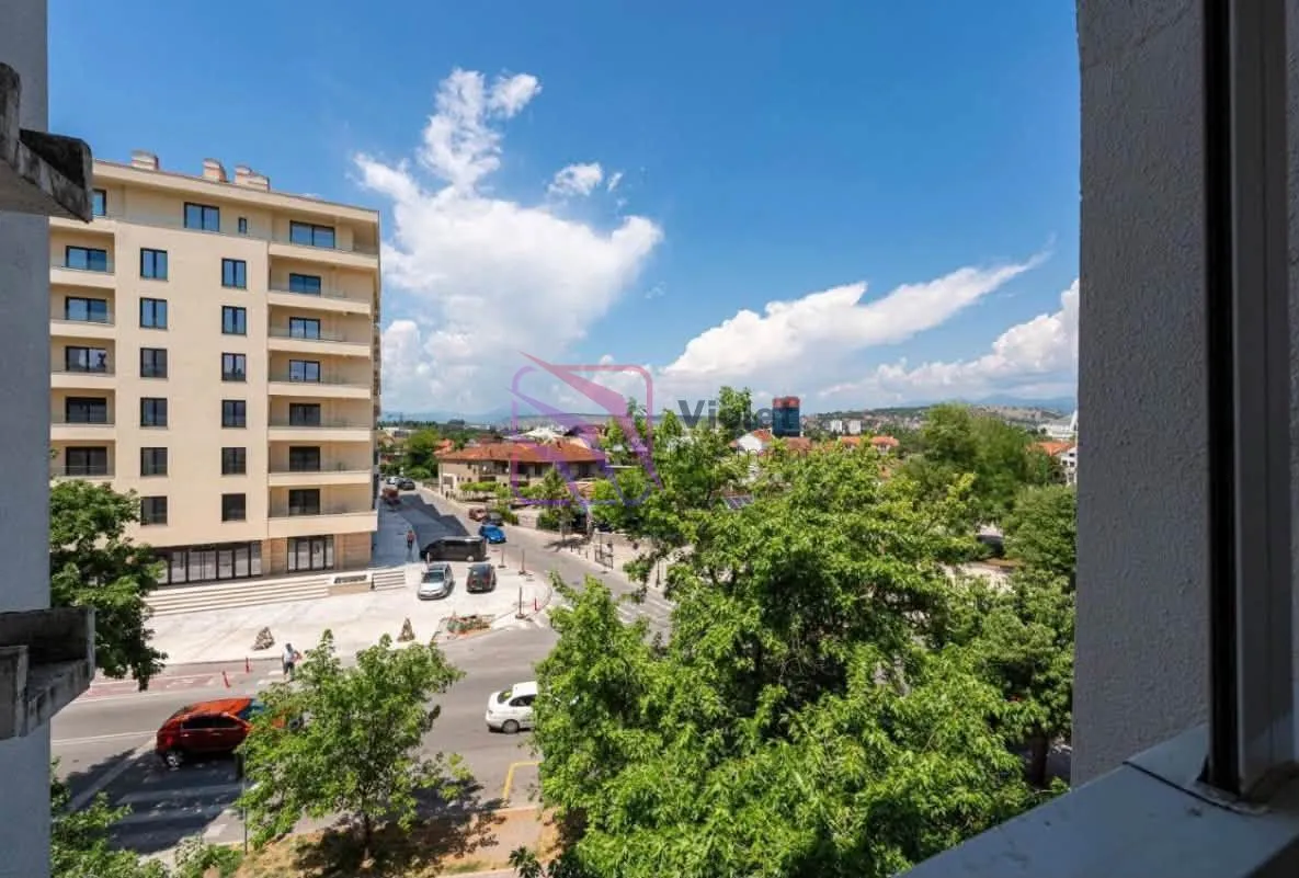 View from the window overlooking the city street and surrounding buildings.