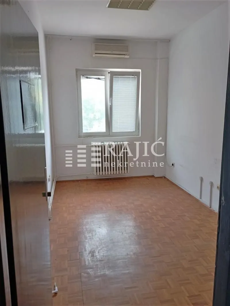 Empty room with parquet flooring and a window.