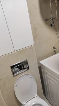 View of the bathroom with a built-in toilet and tiles. - image 2