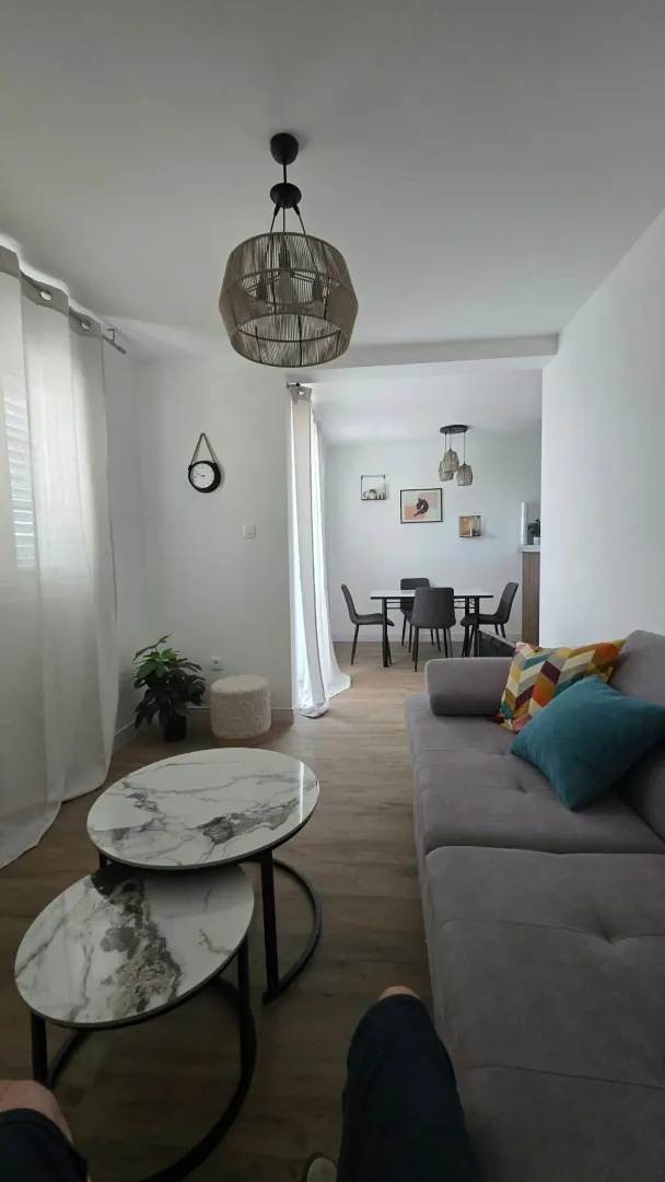 Living room with a sofa, coffee table, and view towards the dining area.