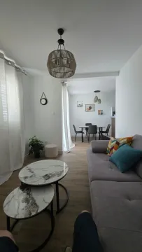 Living room with a sofa, coffee table, and view towards the dining area. - image 14