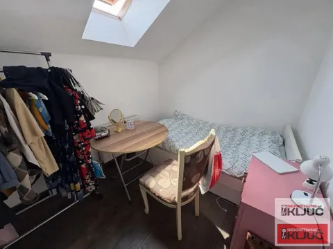 Manja spavaća soba pod kosinom sa krevetom, stolom i stalkom za odeću. - image 12