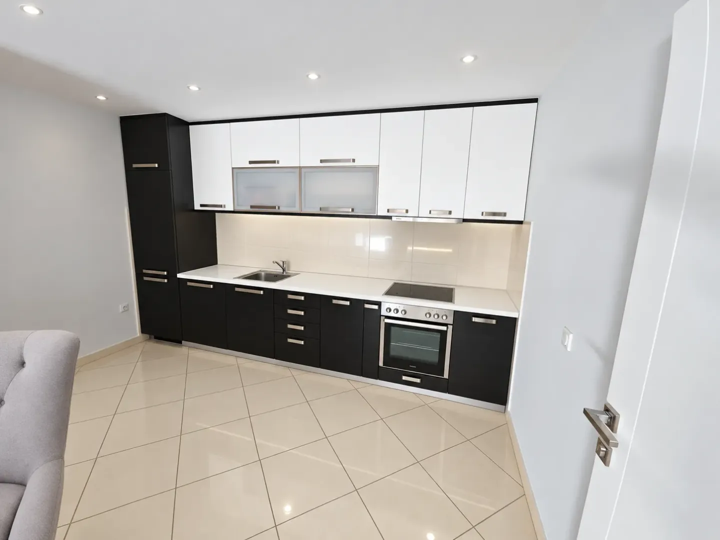 Modern kitchen with dark and white cabinets and built-in appliances.