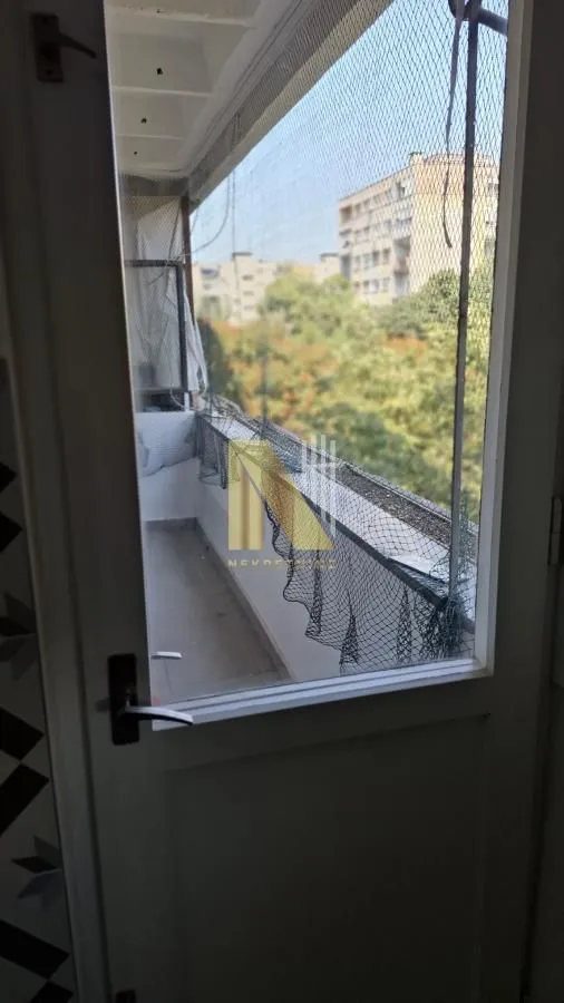 Pogled na natkrivenu terasu sa zaštitnom mrežom kroz vrata.