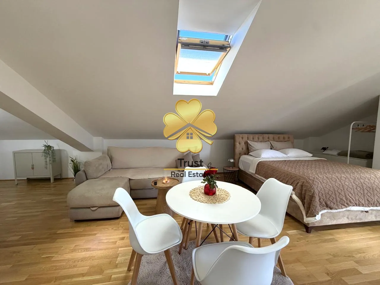 Attic space furnished as a living room with a bed and dining area.