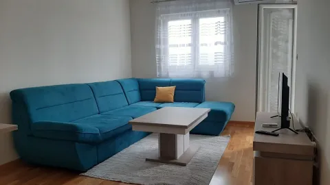 Svijetla dnevna soba sa plavom ugaonom garniturom i klub stolom. - image 8