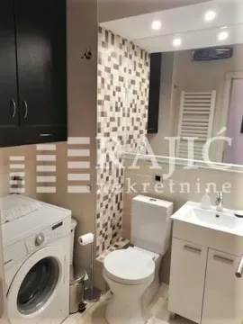 Smaller bathroom with sanitary facilities, a sink, a cabinet, and a washing machine. - image 11