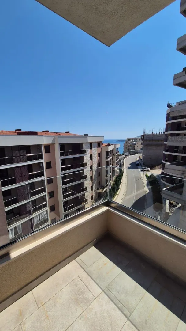View from the terrace overlooking city streets and the sea in the distance.
