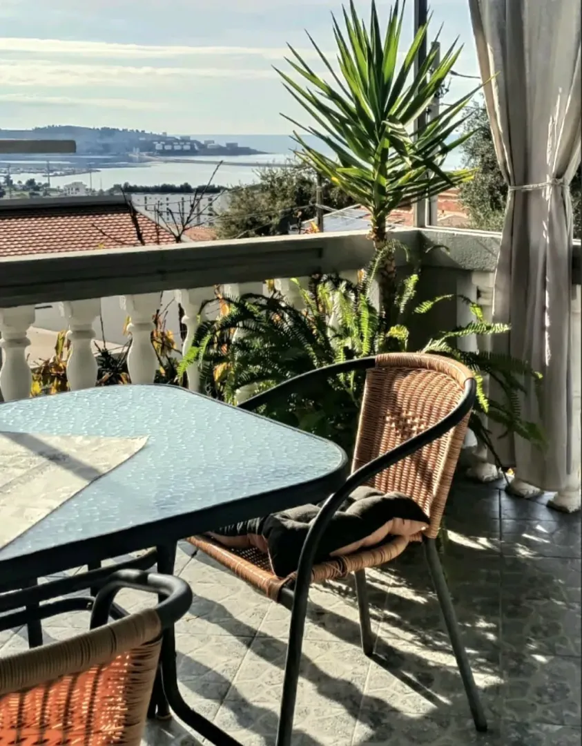 Furnished terrace with a table, chairs, and sea view.