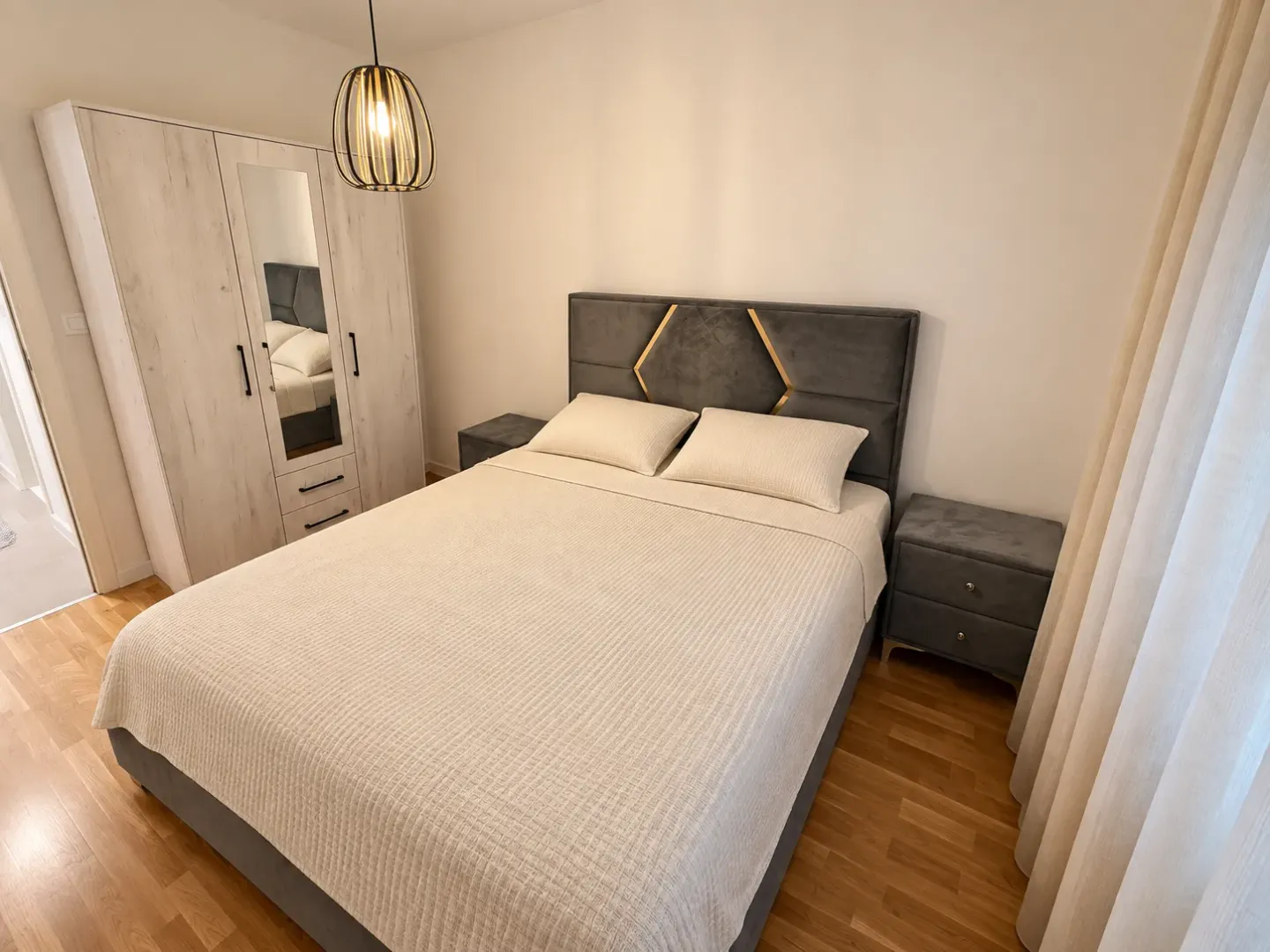 Furnished bedroom with a double bed, wardrobe, and nightstands.