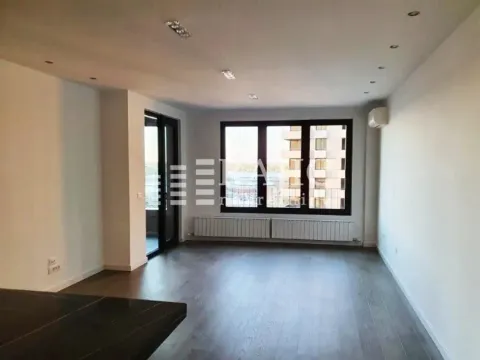 Spacious empty living room with large windows and hardwood flooring. - image 7