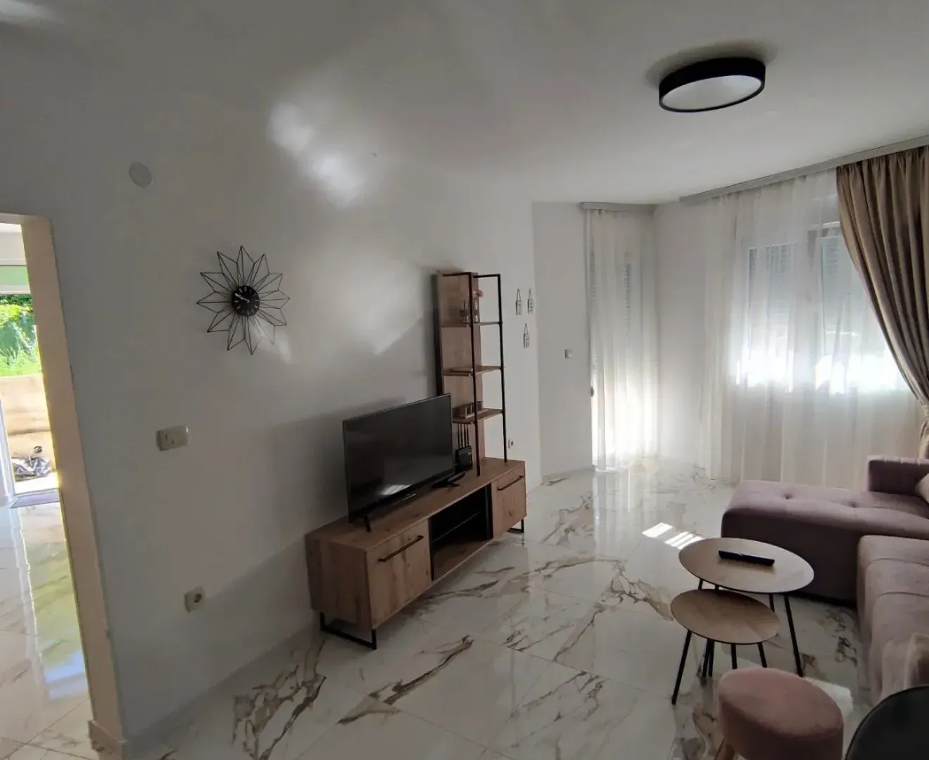 Bright living room with a sofa and TV cabinet.