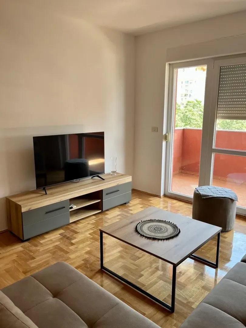 Living room with sofa, TV unit, and access to the terrace.