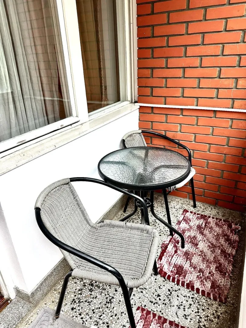 Mali balkon sa okruglim stolom i dvije stolice.