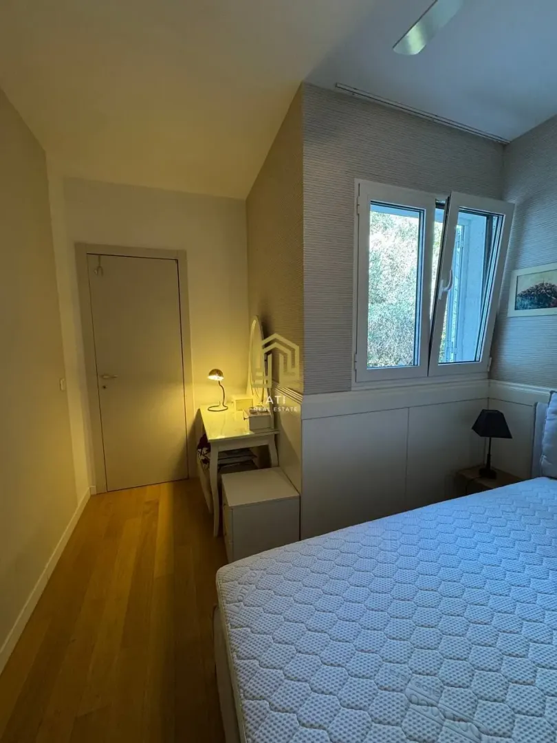 Furnished bedroom with a bed, window, and desk.