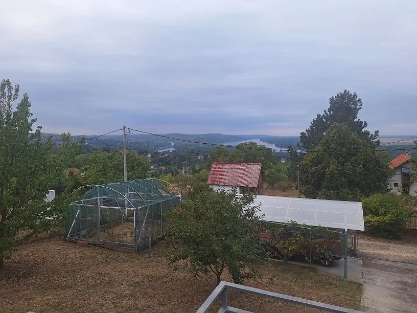 Pogled iz vazduha na dvorište i okolni pejzaž sa rekom u daljini.