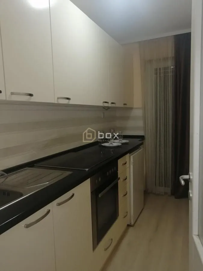 Small kitchen with white cabinets and built-in appliances.