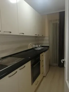 Small kitchen with white cabinets and built-in appliances. - image 6