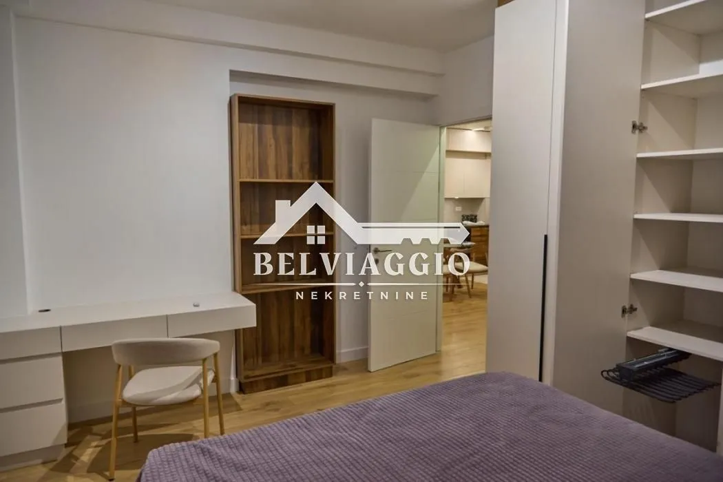 Furnished bedroom with a bed, wardrobe, and desk.