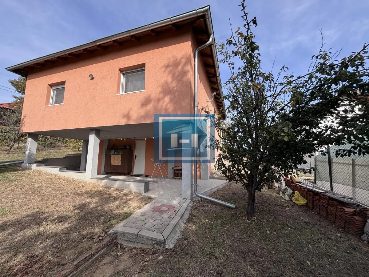 Pogled na dvorište i spoljašnjost kuće sa natkrivenim delom u prizemlju.