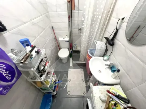Manje kupatilo sa tuš kabinom, umivaonikom, WC šoljom i policama za odlaganje. - image 7