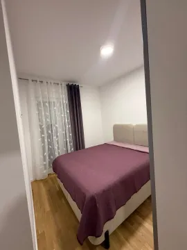 Spavaća soba sa bračnim krevetom i prozorom sa zavjesama. - image 5