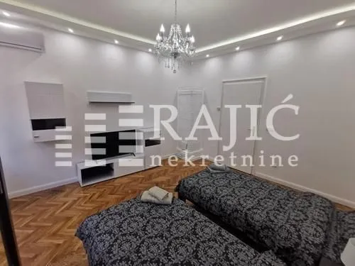 Furnished bedroom with two single beds and white furniture.