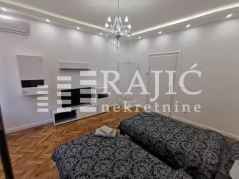 Furnished bedroom with two single beds and white furniture. - image 6