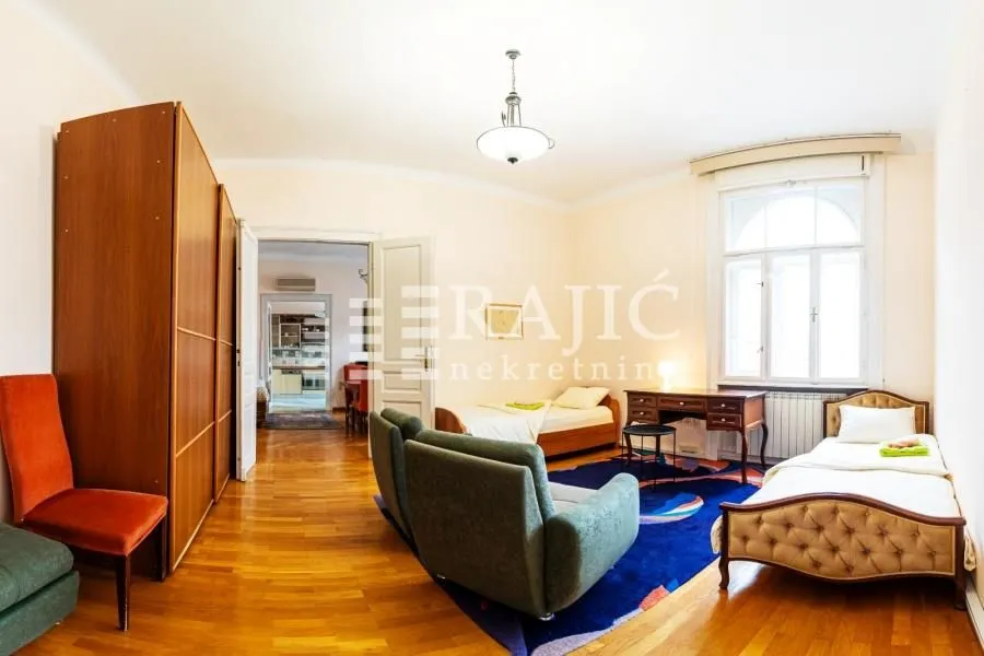 Spacious bedroom with two single beds, a desk, and a wardrobe.