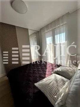 Furnished bedroom with a double bed, wardrobe, and a large window. - image 2