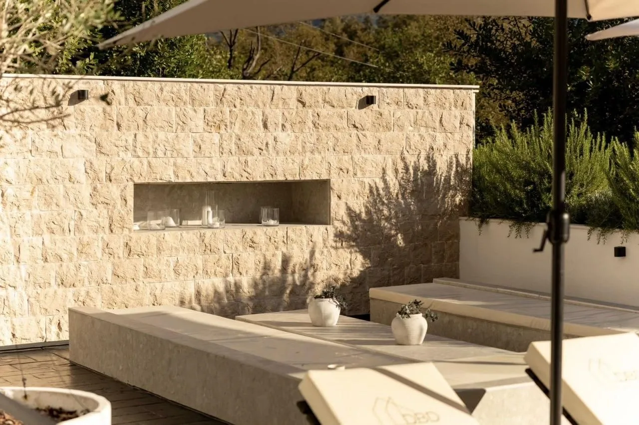 Landscaped yard with a stone wall and seating area.