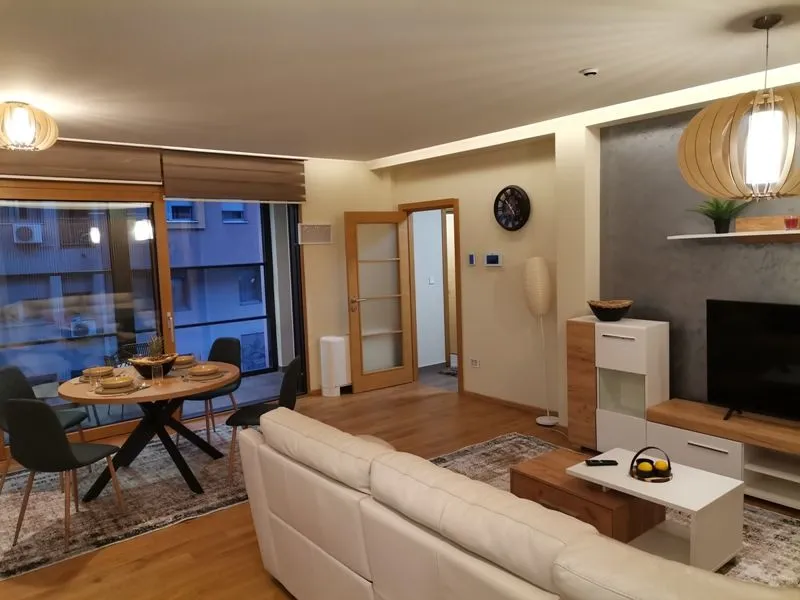 Spacious living room with a dining area, sofa set, and access to the terrace.
