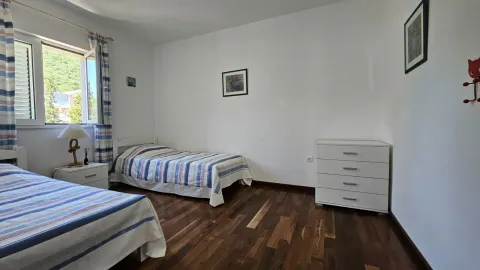 Spavaća soba sa dva kreveta, komodom i prozorom. - image 15