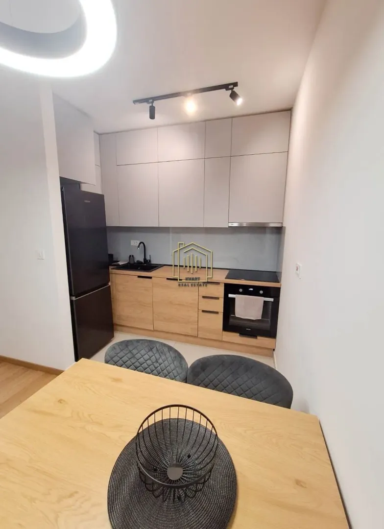 Modern kitchen with wooden elements and a dining table.