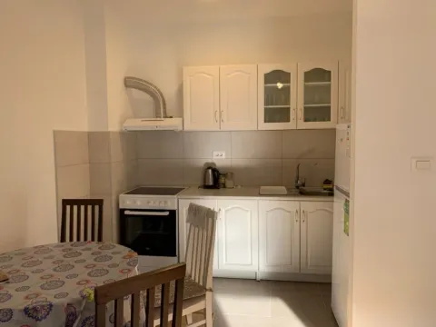 Bright kitchen with white cabinets and a dining table. - image 6