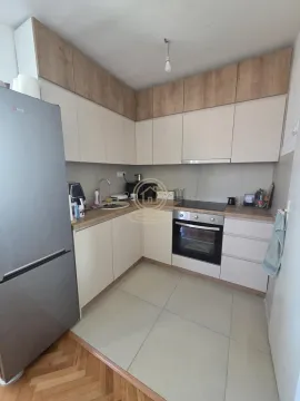Kuhinja opremljena elementima u svetlim tonovima i drvenim detaljima. - image 6
