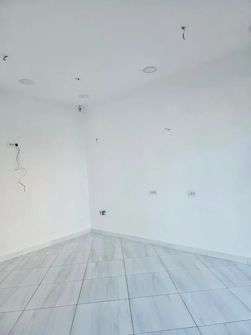 Empty room with white walls and a tiled floor.