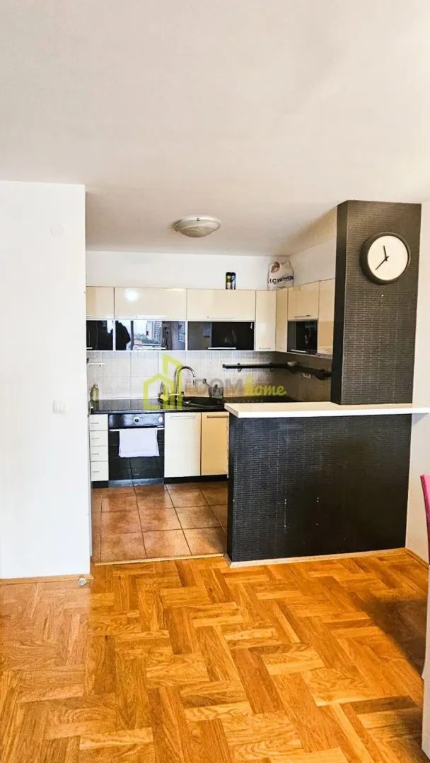 Small kitchen with cabinets and a breakfast bar integrated with the living area.