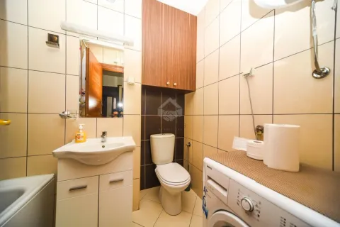 Kupatilo opremljeno umivaonikom, WC šoljom, ormarićem i veš mašinom. - image 8