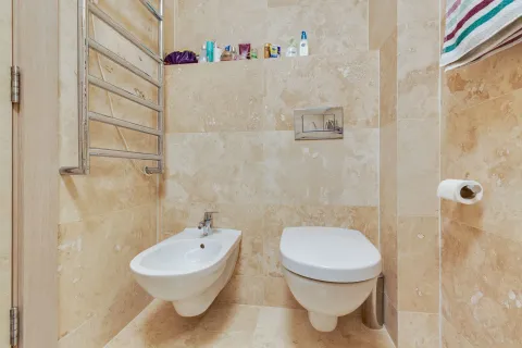 Kupatilo sa toaletom, bideom i keramičkim pločicama u bež tonovima. - image 18