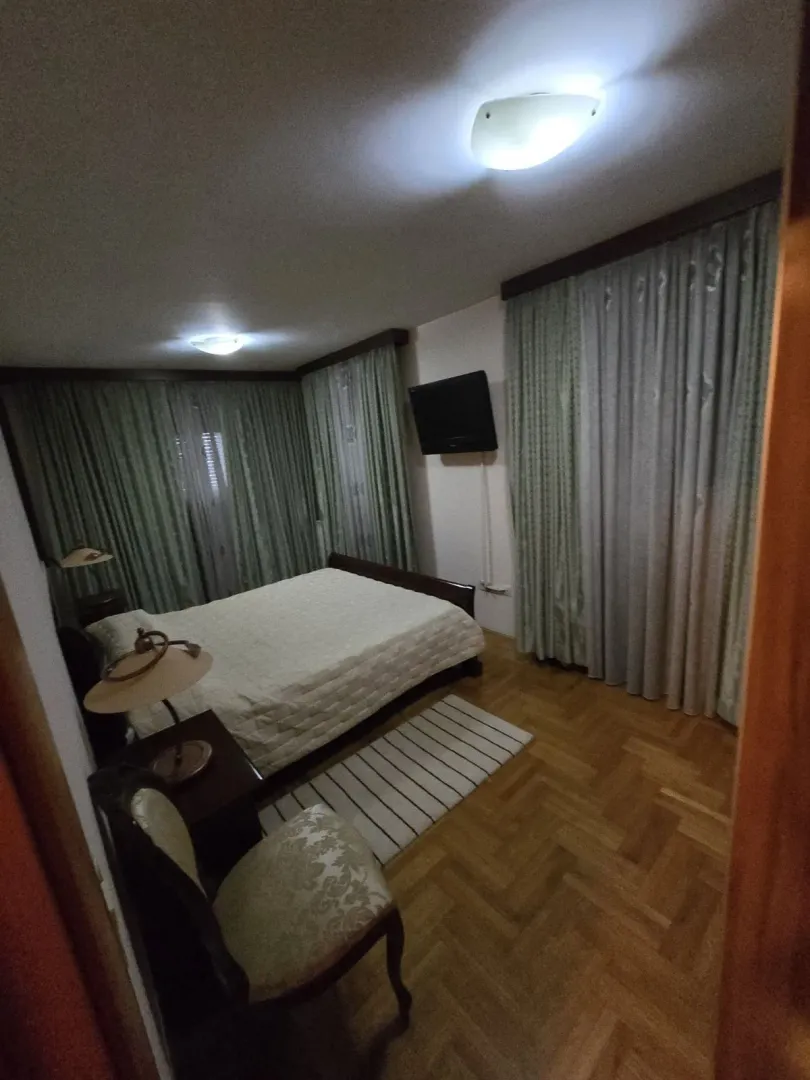 A simply furnished bedroom with green curtains.