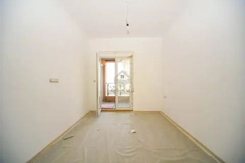Prazna neuređena prostorija sa balkonskim vratima i podom prekrivenim zaštitnom folijom. - image 4