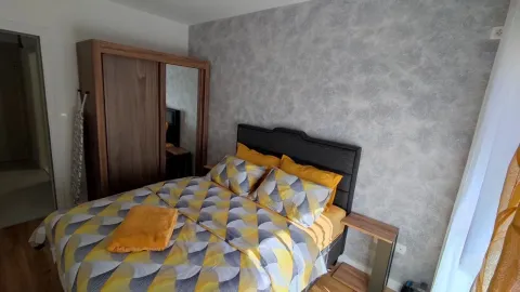 Bright bedroom with a double bed and a wooden wardrobe. - image 4