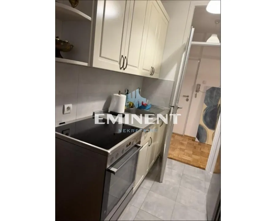 Small kitchen with white cabinets and a stove.