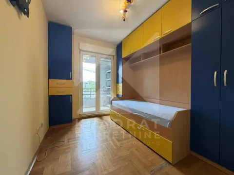 Children's bedroom with a bed and blue and yellow wardrobes. - image 7