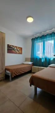 Namještena spavaća soba sa dva kreveta i ormarom. - image 8