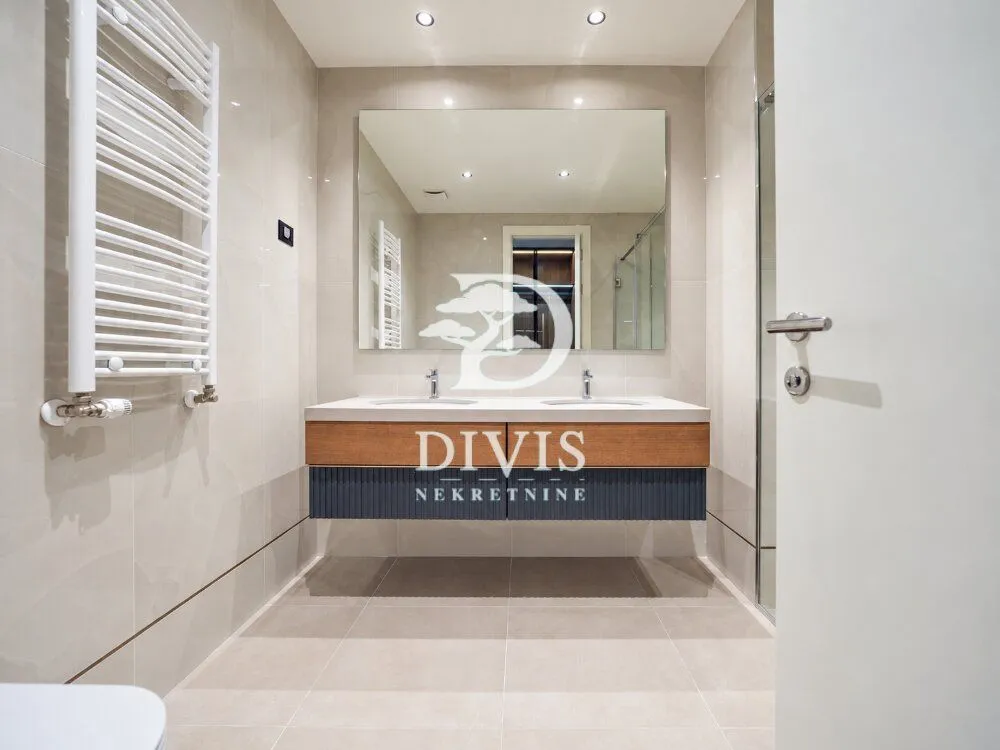Modernly equipped bathroom with a double sink and a large mirror.